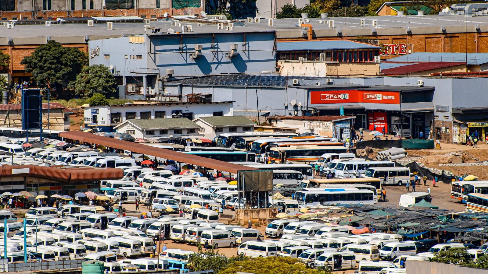 Minibus taxis, buses, traders and pedestrians at a taxi rank in Mbabane, Eswatini.