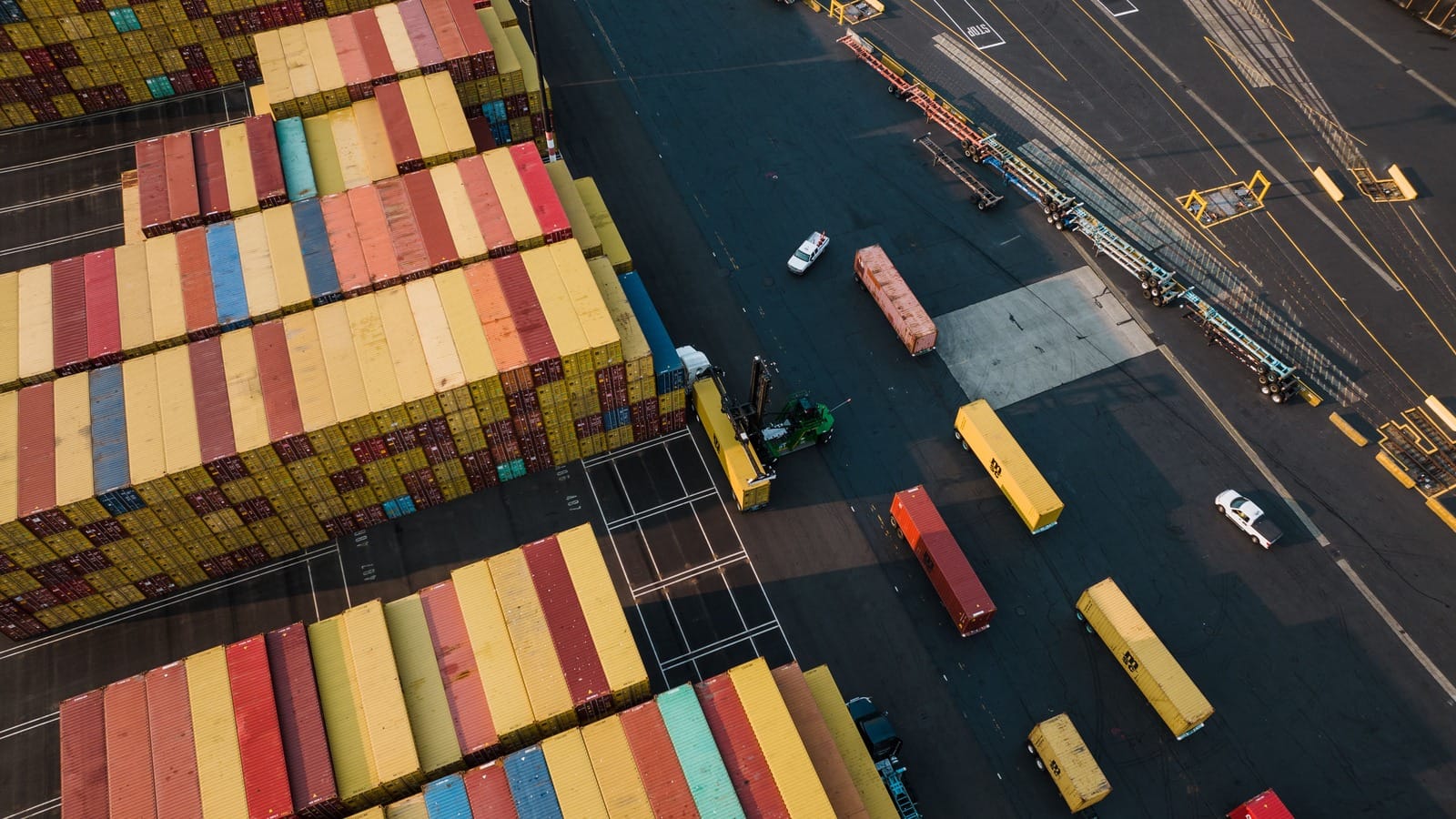 Aerial photograph of stacked containers, loading equipment and traffic lanes at a Seattle port.